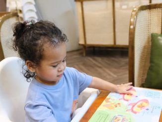 Young child pointing at a colorful menu.