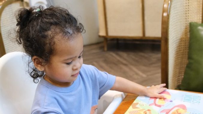 Young child pointing at a colorful menu.